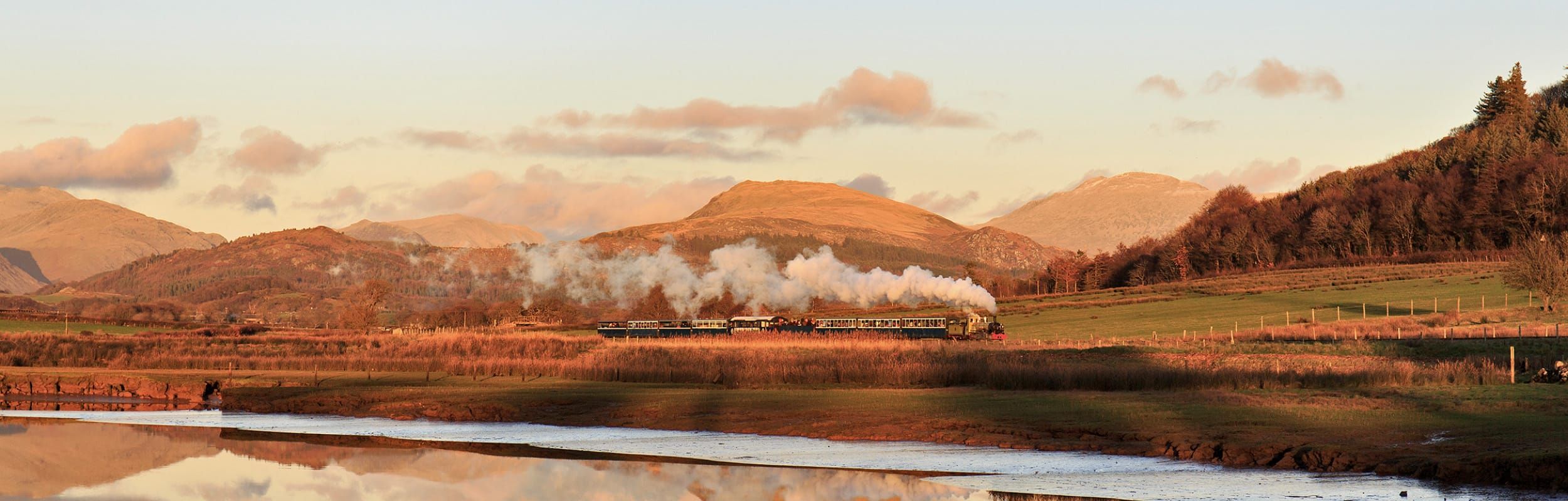 Steam railway train on the Ravenglass and Eskdale railway, with the stunning backdrop of the Western Lake District fells