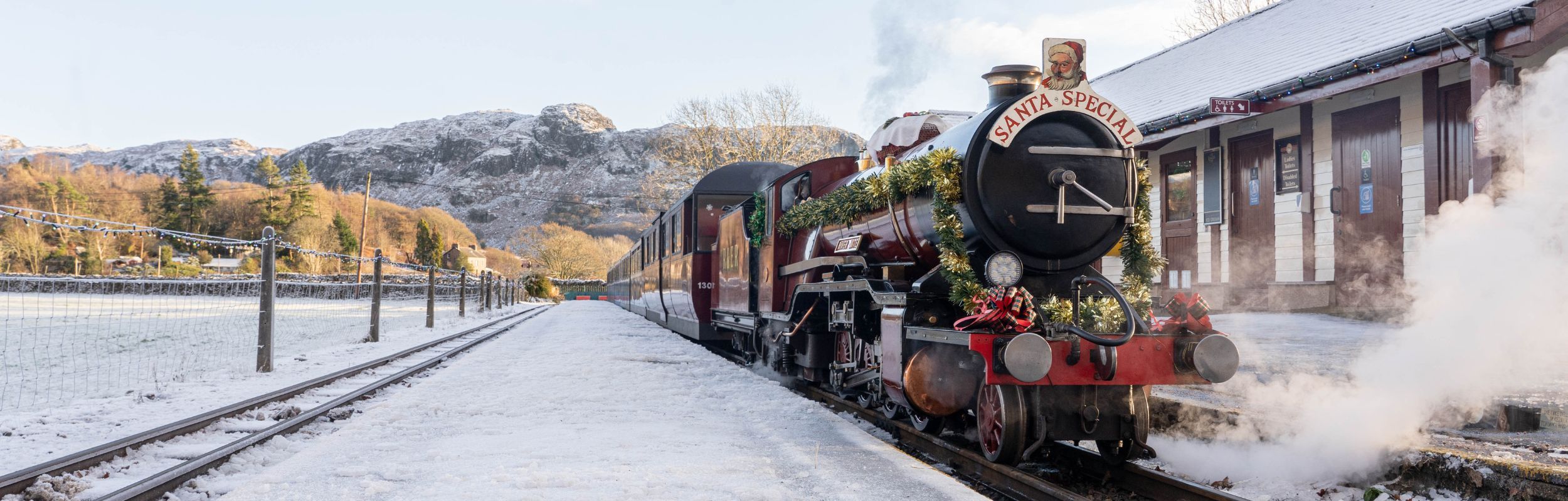 A steam locomotive dressed up for the Santa Express trains in the snow at the Ravenglass and Eskdale Railway