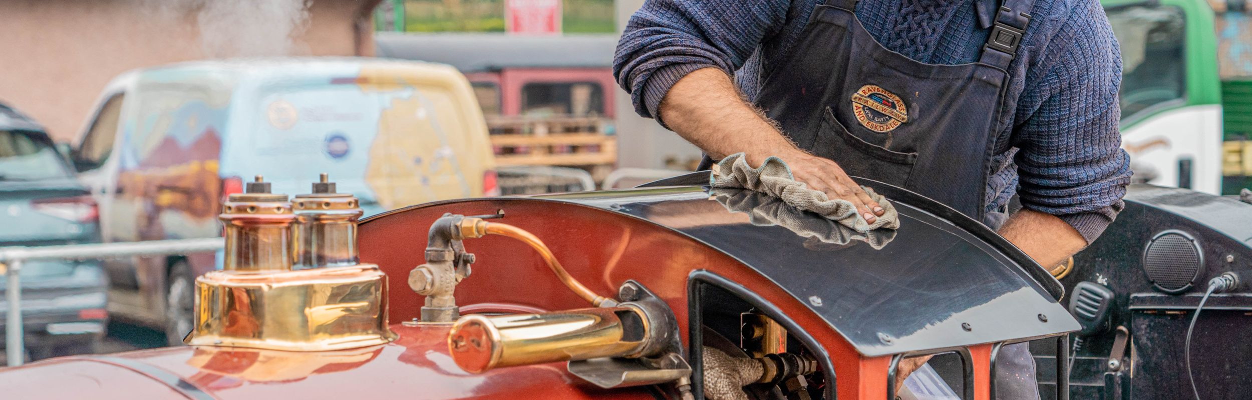 A train driver tending to his steam engine at the Ravenglass and Eskdale Railway