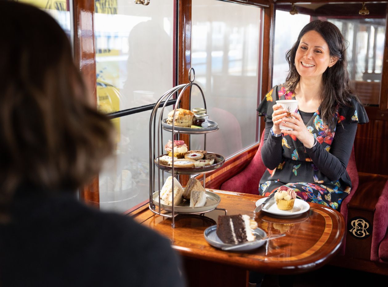 Two females enjoying a Cream Tea on the Move experience in the 'Ruth' carriage at the Ravenglass and Eskdale Railway