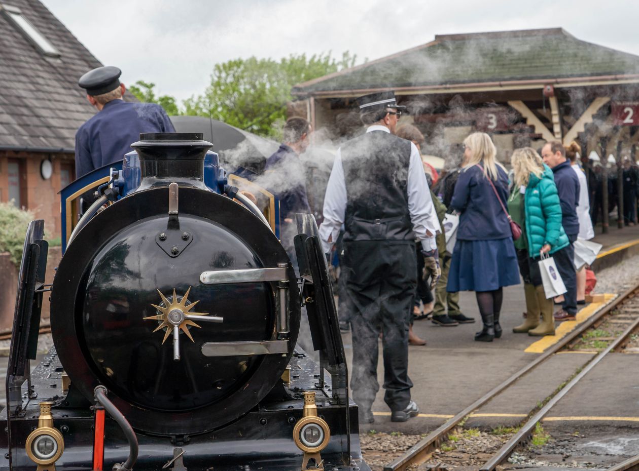 A group of passengers disembarking a train at the Ravenglass and Eskdale Railway